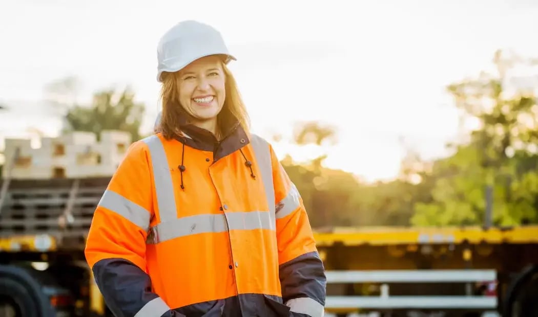 a happy construction worker wearing a hard hat and fluorescent jacket a happy construction worker wearing a hard hat and fluorescent jacket