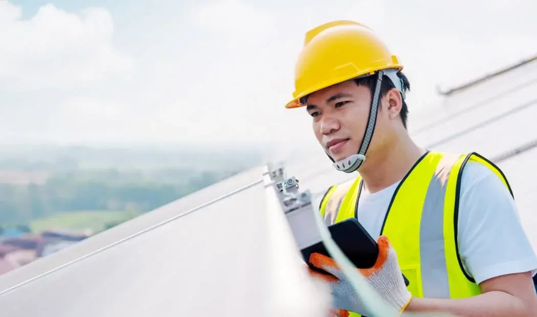 Energy industry worker wearing PPE with a hand-held tablet