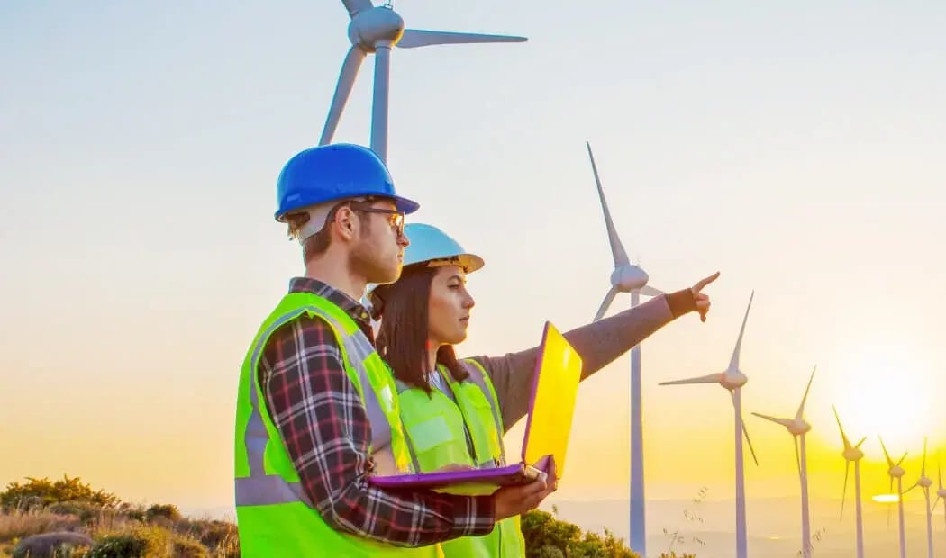 Energy industry workers wearing PPE on-site at a wind farm