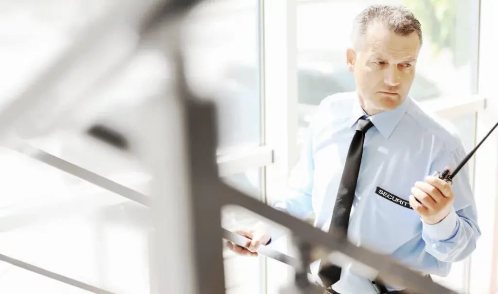 security personnel on stairs with walkie-talkie in hand