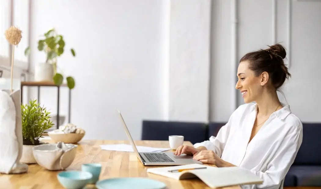 employee working at a laptop on a desk employee working at a laptop on a desk