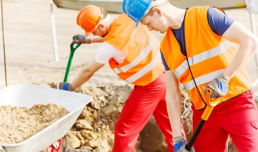 Construction workers shovelling
