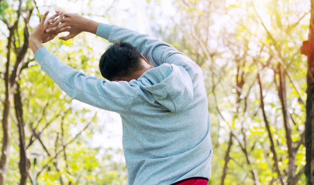 A person in a sweatshirt stretching A person in a sweatshirt stretching