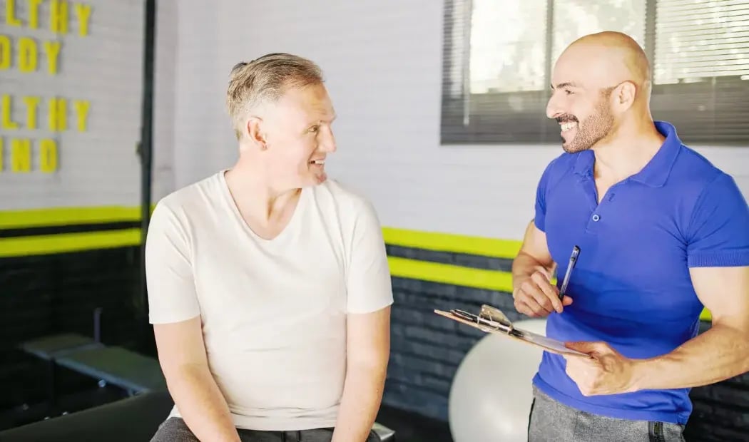 a worker in discussion with a health and wellbeing team member