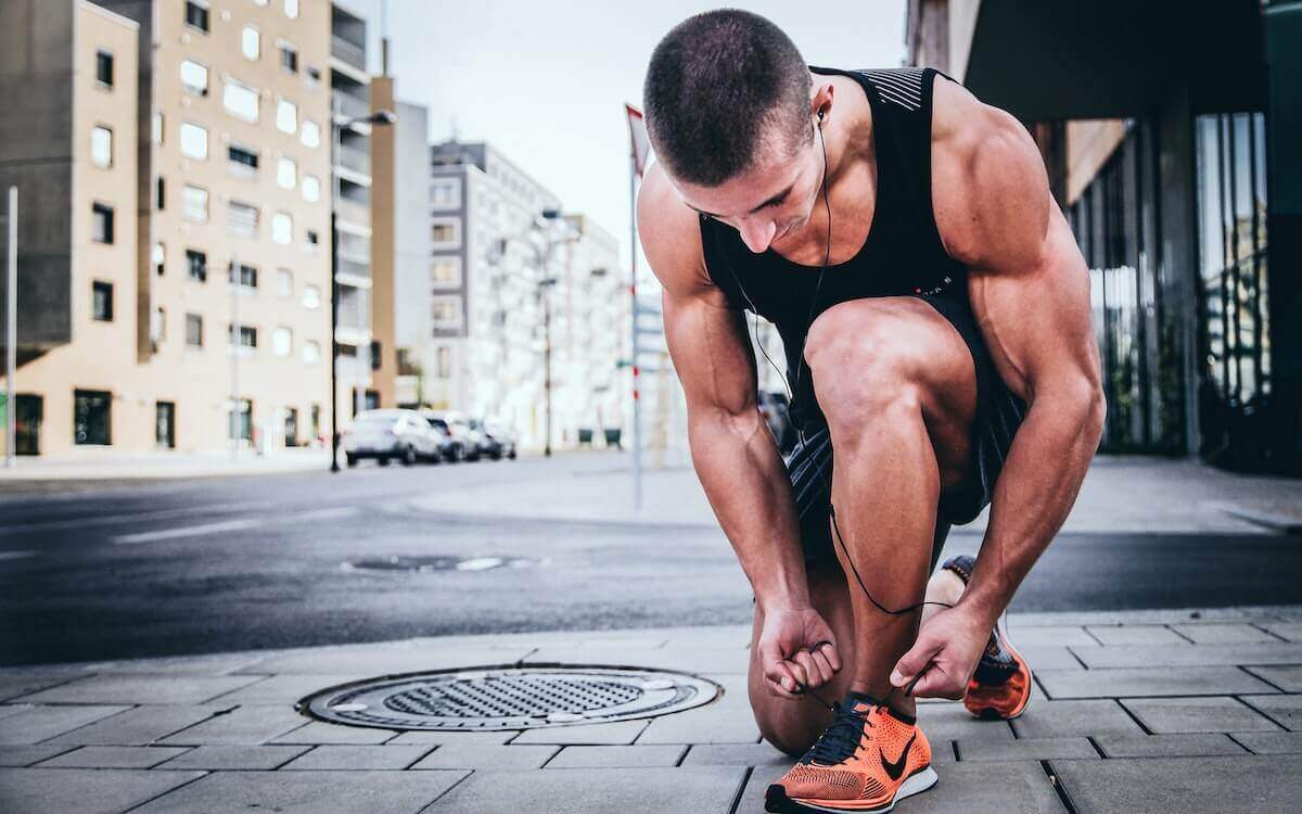 Athletic looking man in running gear tying shoelaces
