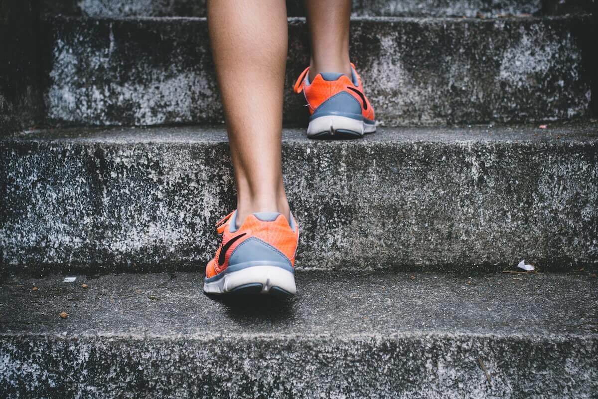 Close up of someone's feet in trainers walking up steps