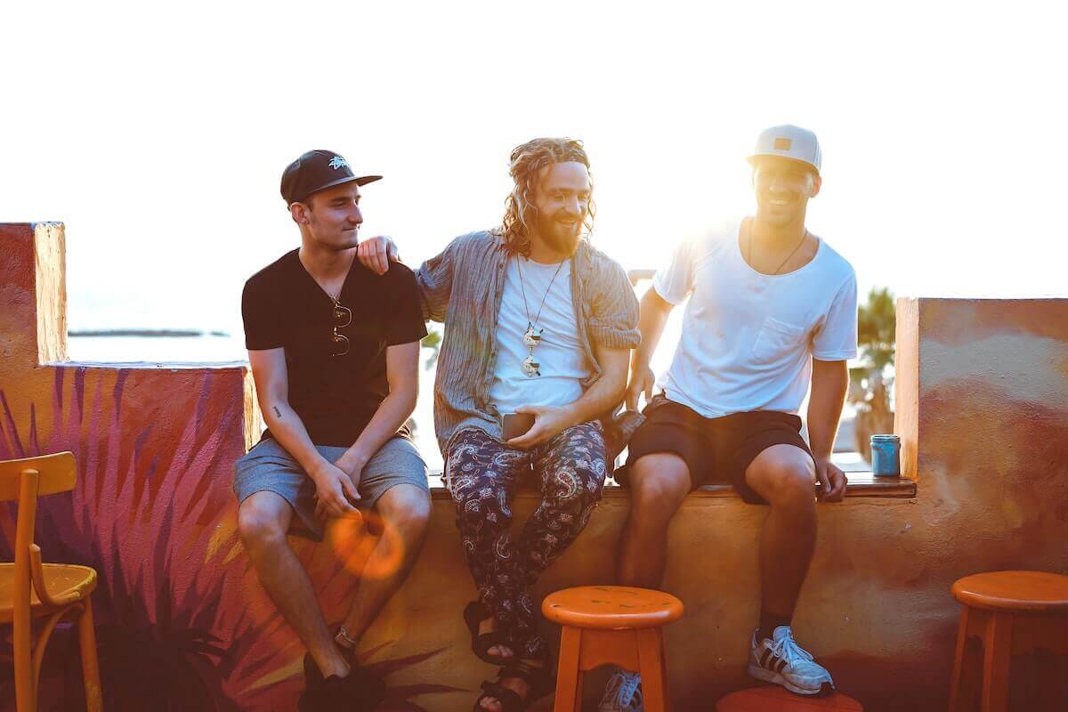 Three Men sat together at an outside cafe bar