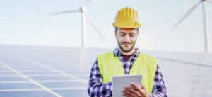 An energy industry worker on-site at a solar and wind farm