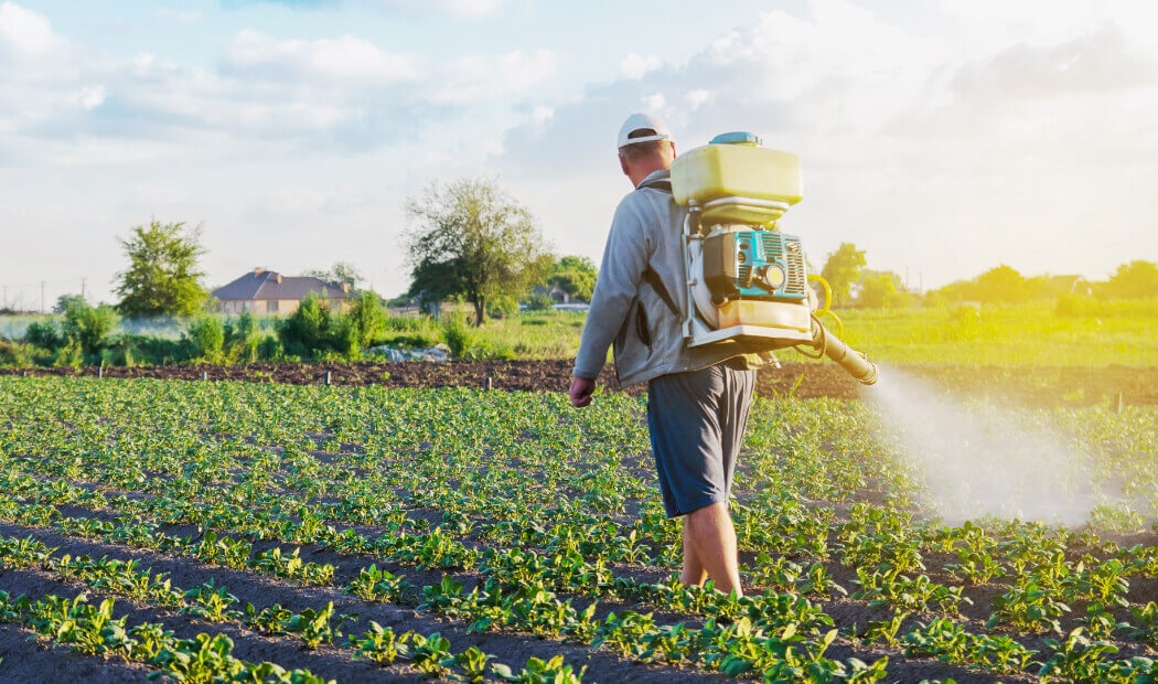 a farm worker spraying crops