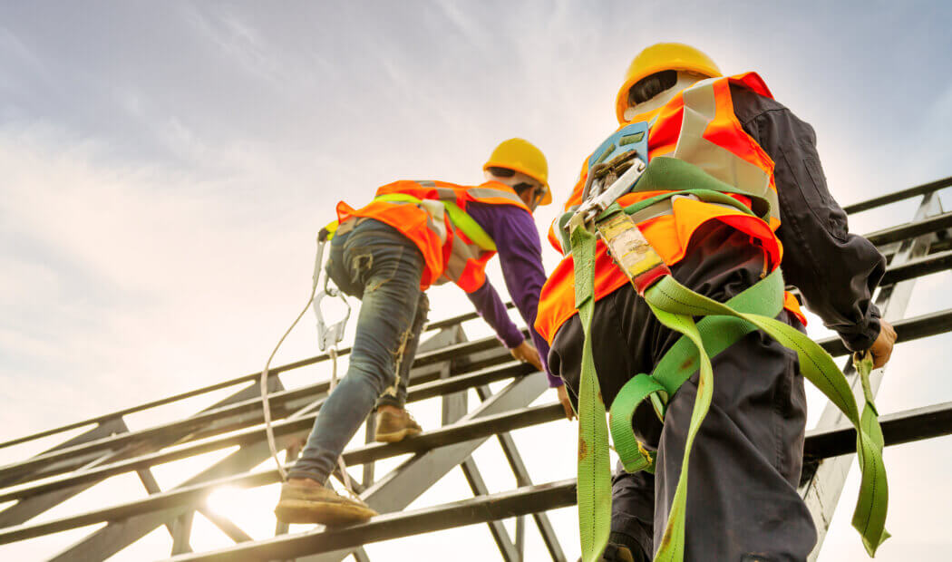 construction workers in PPE and harnesses to ensure workplace safety