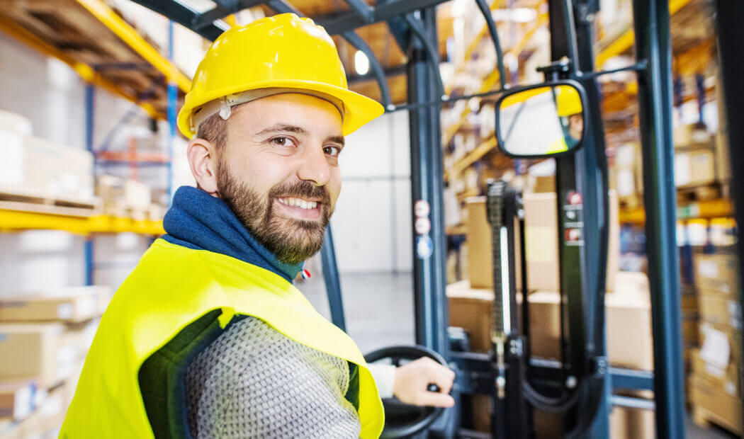 worker in PPE operating a forklift