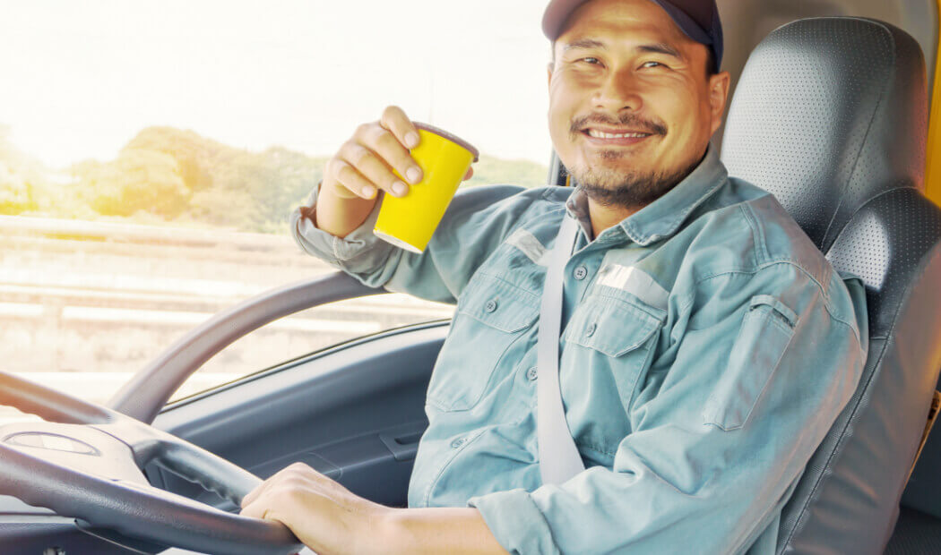 transport worker in vehicle with drink in hand