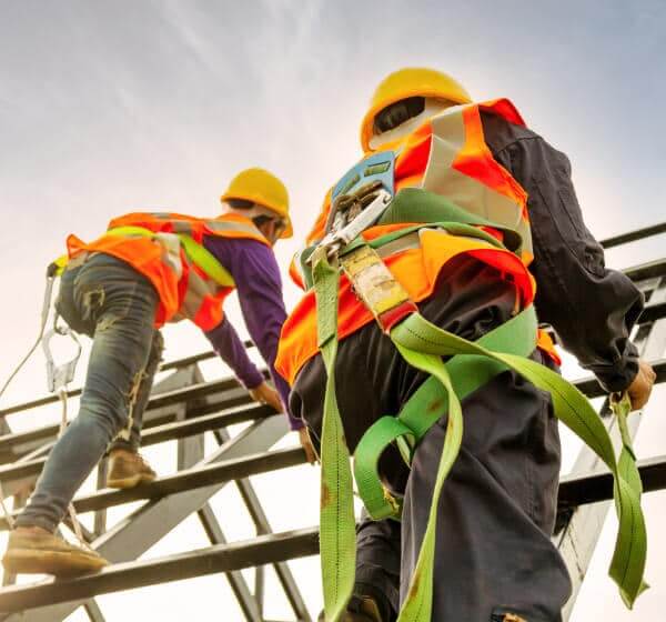Construction workers in safety harnesses