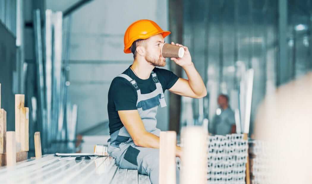 a young man in a hard hat on a coffee break