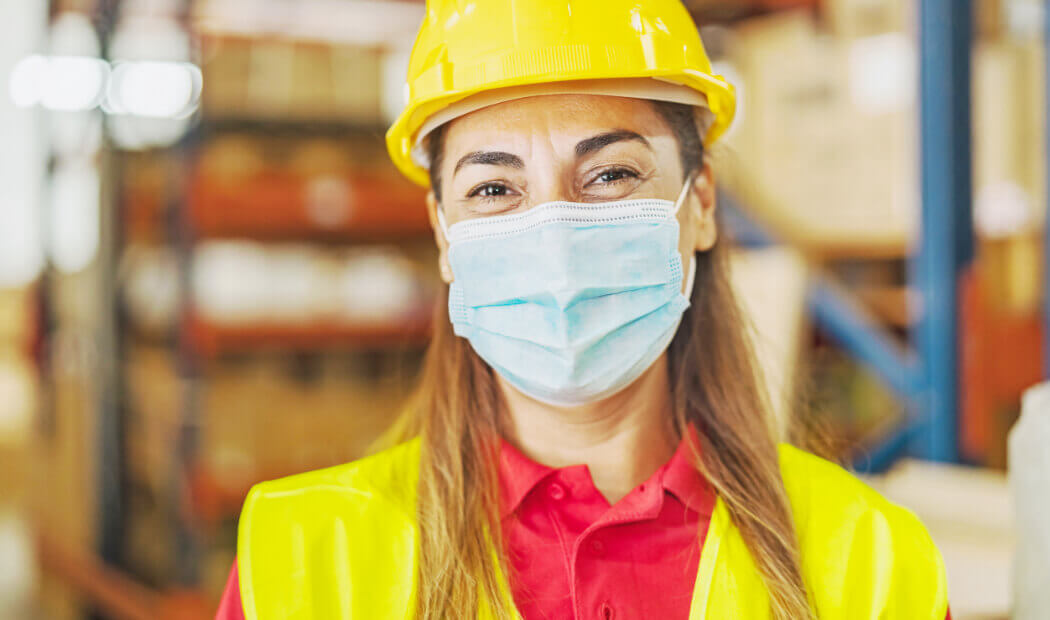 staff member in a warehouse wearing a face mask