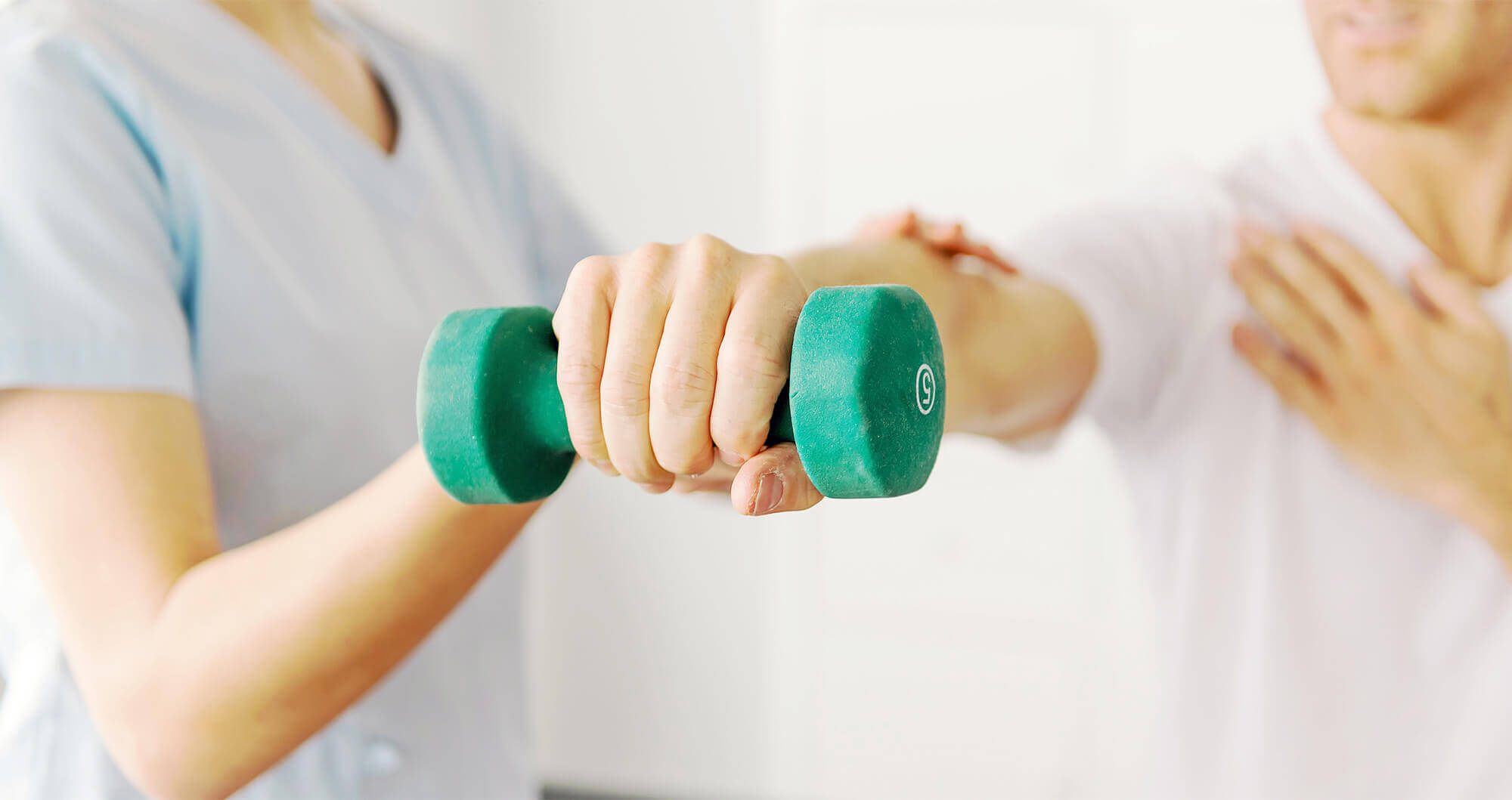 A close-up of an outstretched hand holding a dumbbell