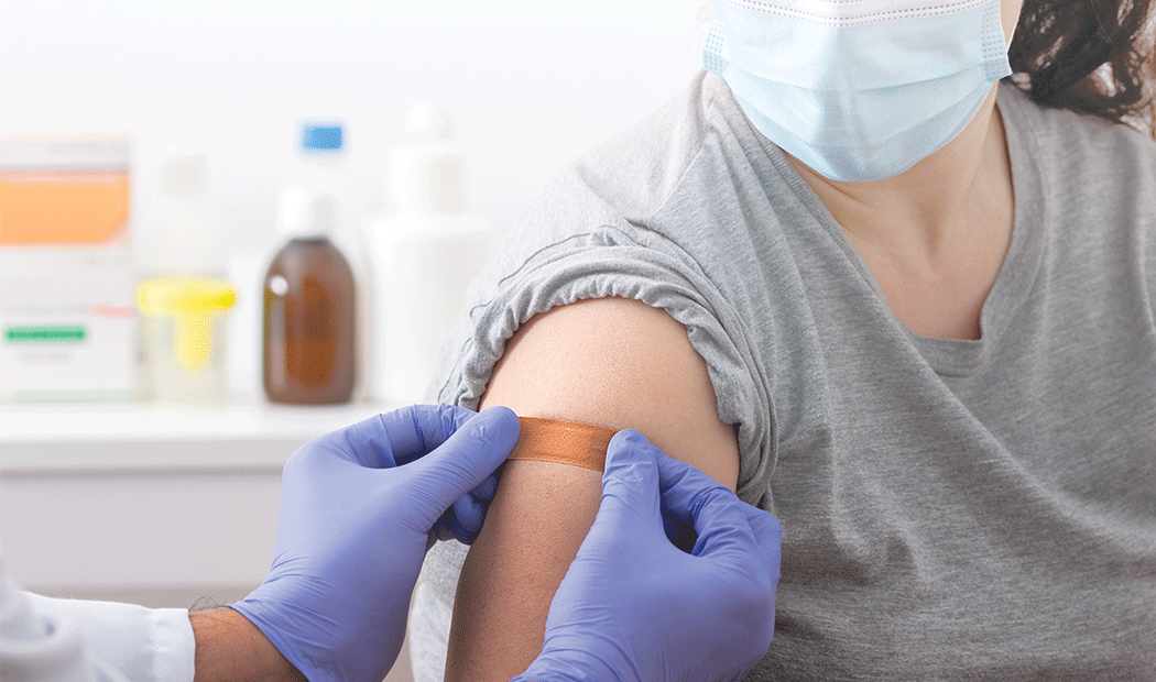 plaster being applied to arm on site of vaccination