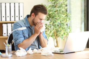 Sick man blowing nose with flu